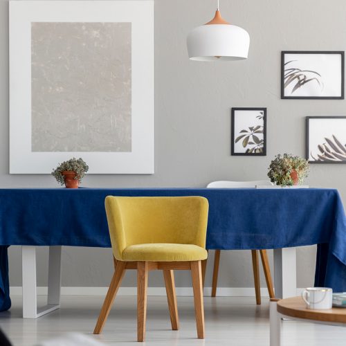 Yellow wooden chair at table with blue cloth in modern dining room interior with mockup. Real photo; Shutterstock ID 1197594847; Purchase Order: -
